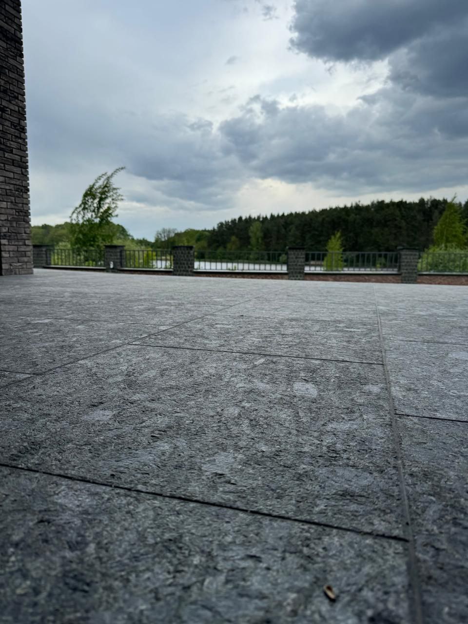 Large terrace installation with Black Ice L7 pavers under dramatic sky