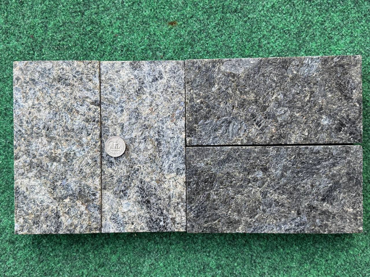 Top view of Black Ice L7 pavers with coin for scale